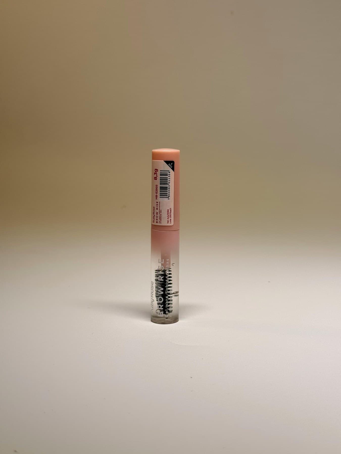 Gloss tube standing on warm neutral studio background