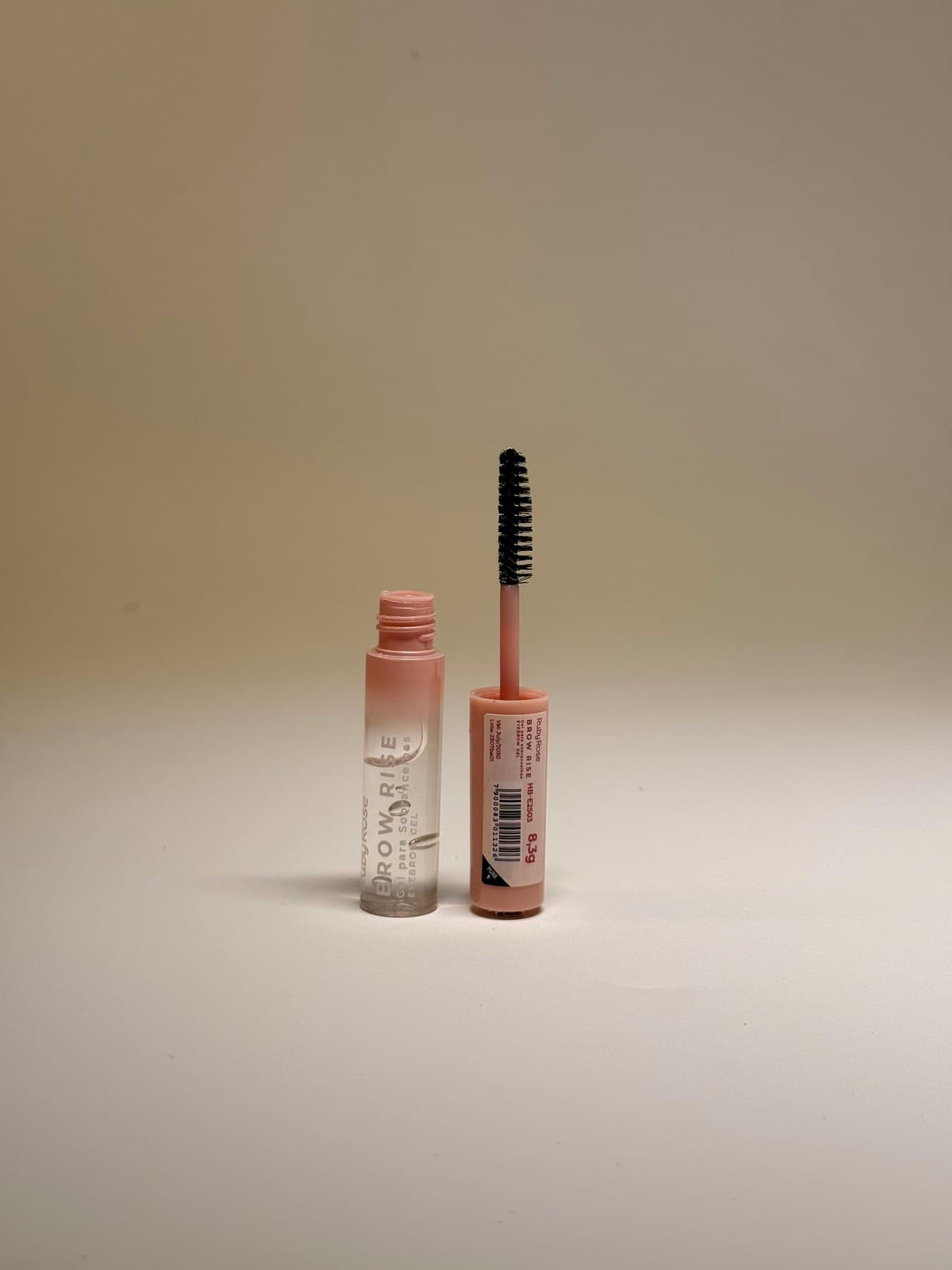 Mascara-style beauty tube with precision brush on neutral backdrop