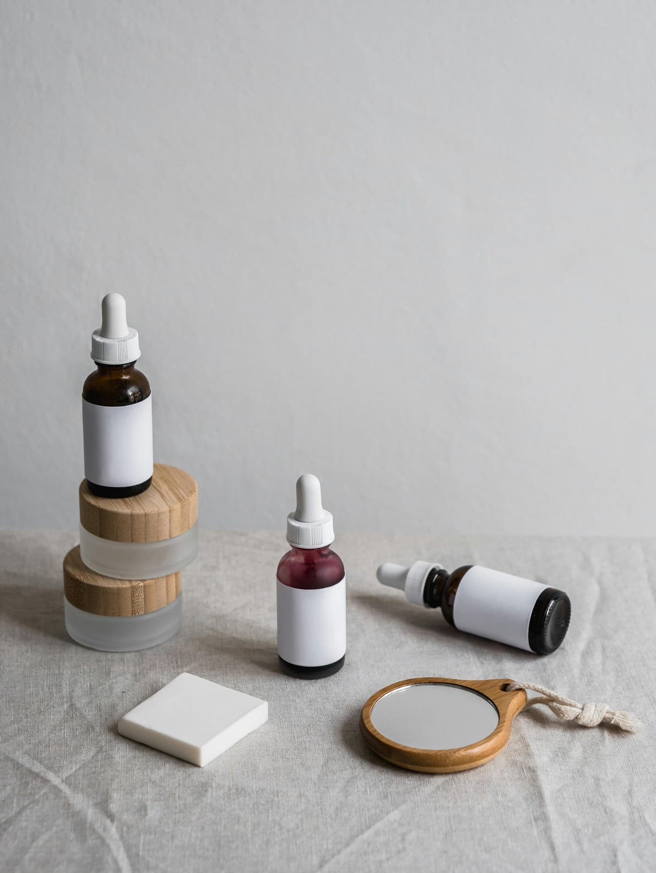 Glass serum bottles and skincare ritual arranged on linen
