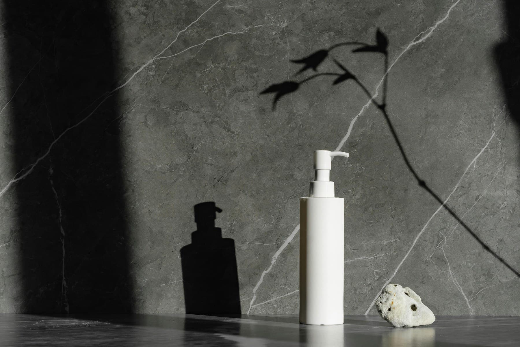 Luxury pump bottle on stone surface with directional light
